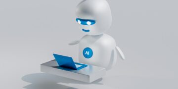 a white robot with blue eyes and a laptop